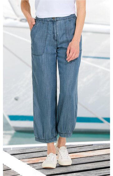 Damenhose in mittelblau, einfarbig, elastischer Bund mit Kordel, zwei große vordere Taschen, gerade geschnitten, elastische Bündchen am Knöchel, getragen von stehender Person, Casual-Stil
