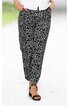 Schwarze Hose mit weißem, geschwungenem Muster, gerade geschnitten, seitliche Eingrifftaschen, getragen von stehender Person, kombiniert mit schwarzen Sandalen mit Absatz