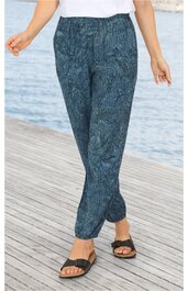 Dunkelgrüne lange Hose mit bläulichem Muster, elastischem Bund, seitlichen Taschen, schmal zulaufend, getragen von stehender Person, kombiniert mit schwarzen Sandalen