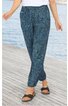 Dunkelgrüne lange Hose mit bläulichem Muster, elastischem Bund, seitlichen Taschen, schmal zulaufend, getragen von stehender Person, kombiniert mit schwarzen Sandalen