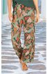 Weite Hose in Beige mit grünem und rotem Blattmuster, elastischer Bund, lang, getragen von stehender Person, locker fallend