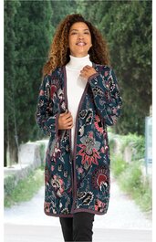Damenmantel in dunkelblau mit farbigem Blumenmuster, lange Form, V-Ausschnitt, offene Front ohne Verschluss, getragen von stehender Frau mit weißem Rollkragenpullover und schwarzen Hosen