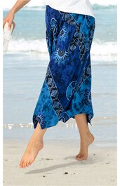 Rock in verschiedenen Blautönen mit Batikmuster, asymmetrischer Saum, getragen von Person am Strand, knöchellang, elastischer Bund