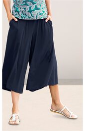 Damenweite Cropped Hose in Dunkelblau, ohne Muster, mit seitlichen Taschen, elastischer Bund, weite Beinform, knöchellang, getragen von stehender Person