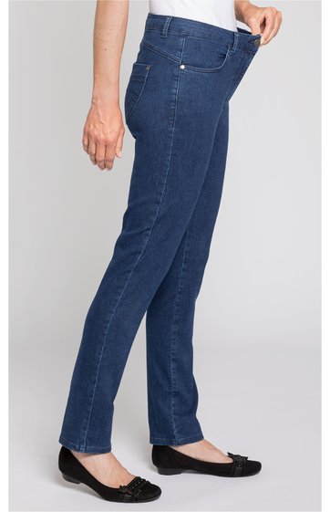 Dunkelblaue Jeanshose, gerade geschnitten, fünf Taschen, getragen von seitlich stehender Person, Person hält Bund mit linker Hand, Schuhwerk schwarze Ballerinas