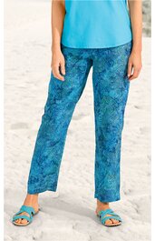 Hose in Blau mit abstraktem Muster in dunklerem Blau, gerade Form, taillierte Passform, getragen von stehender Person mit sandigem Untergrund