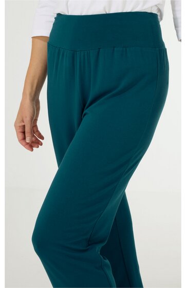 Dunkeltürkise Hose mit weitem Bein, breitem Bund, schlichten Details, getragen von stehender Person, elastischer Bund für Komfort