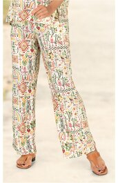 Weite Hose in hellbeige mit buntem geometrischem Muster, hoher Bund mit Knopf und Reißverschluss, getragen von stehender Person mit sandfarbenen Sandalen