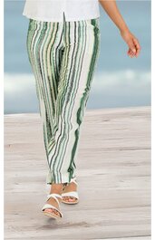 Hose in Weiß mit grünen und schwarzen vertikalen Streifen, gerader Schnitt, getragen von stehender Person, elastischer Bund, hüftlang, offene weiße Sandalen