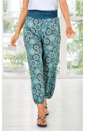Hose türkis mit kreisförmigem floralem Muster in Weiß, Marineblauer breiter Bund, Beinabschluss elastisch, gerade geschnitten, getragen von stehender Person, lockere Passform