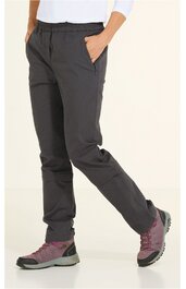 Dunkelgraue Outdoorhose mit elastischem Bund, seitlichen Eingrifftaschen, schmal zulaufendem Bein, getragen von stehender Person mit rechter Hand in Tasche, kombiniert mit dunkelrosa Wanderschuhen und weißen Oberteil