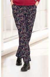 Dunkelblaue lange Hose mit bunter, abstrakter Musterung in Rot, Weiß und Beige, gerader Schnitt, getragen von stehender Person mit Händen in den Taschen, schwarze Schnürstiefel sichtbar