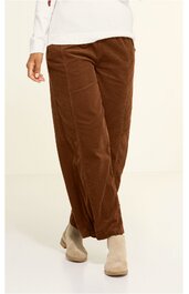 Braune Hose mit geradem Schnitt, hoher Bund, ohne Muster, getragen von stehender Person, ausgestellt, kombiniert mit hellen Stiefeletten