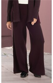 Dunkelbraune weite Hose ohne Muster, mit geradem Schnitt, getragen von stehender Person, hoher Bund, kombiniert mit dunkelbraunem Oberteil