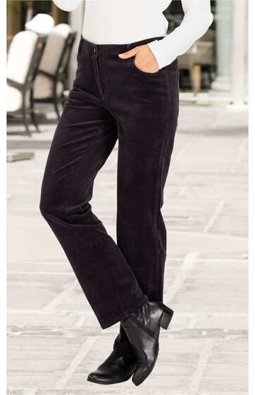 Schwarze Hose mit geradem Schnitt, hohe Taille, seitliche Eingrifftaschen, getragen von stehender Person mit linker Hand in Tasche, kombiniert mit schwarzen Stiefeletten und weißem Oberteil