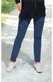 Dunkelblaue lange Hose mit schmaler Passform, getragen von stehender Person, kombiniert mit schwarzem Oberteil und weißen Sneakers