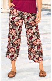 Locker sitzende Hosen in Beige und Rot mit floralem Muster, gerade geschnitten, knöchellang, getragen von stehender Person, elastischer Bund, seitliche Hosentaschen