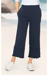 Dunkelblaue Damenhose, gerade geschnitten, elastischer Bund, aufgesetzte Taschen, am Saum kleine Rüschen, knöchellang, getragen von stehender Person mit weißen Sneakers