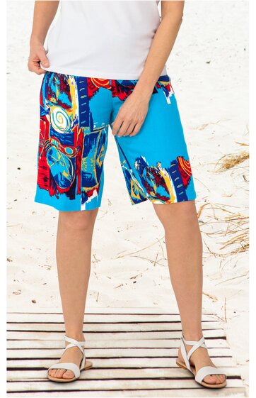 Bermudashorts in Hellblau mit buntem abstraktem Muster in Rot, Gelb, Schwarz und Blau, gerader Schnitt, knielang, getragen von stehender Person mit weißen Sandalen und weißem Oberteil