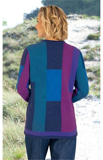 Langärmliges Pulloveroberteil in Blau- und Violetttönen mit rechteckigem Blockmuster, Rundhalsausschnitt, lockere Passform, getragen von stehender Person mit Rücken zur Kamera