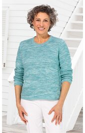 Langärmliger Pullover in meliertem helltürkis, runder Ausschnitt, gerade geschnitten, getragen von stehender Frau mit weißen Haaren und weißen Hosen