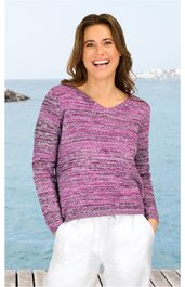 Lila melierter Pullover mit V-Ausschnitt und langen Ärmeln, gerade geschnitten, getragen von lächelnder stehender Frau mit weißen Hosen, Hände in Taschen