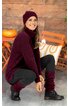 Dunkelroter Rollkragenpullover, schwarze Leggings, dunkelrote Mütze und Beinstulpen, schwarze Schnürstiefel, sitzende Frau, brauner Holzhintergrund mit Kürbissen und Korb