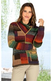 Bunte Strickjacke mit Blockstreifen in Grün, Braun, Rot, Orange, Gelb und Grau, asymmetrischer Umlegekragen mit Knopfverschluss, lange Ärmel, aufgesetzte Taschen mit Reißverschluss, getragen von stehender Frau mit beige Hose