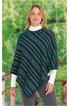 Poncho in dunkelgrün mit diagonalen Streifen in Blau, Grün und Beige, geometrisches Muster, asymmetrischer Saum, getragen von stehender Frau mit weißem Rollkragenpullover und grauer Hose