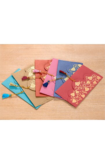 Sechs Briefumschläge in Blau, Beige, Pink, Violett und Rot, mit goldfarbenem floralen Muster, jeder mit einer Quaste am Verschluss, angeordnet auf hellem Holztisch