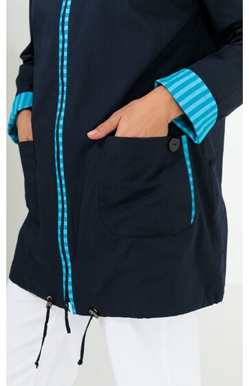 Dunkelblaue Jacke mit türkis-weiß gestreiftem Innenfutter am Reißverschluss und Ärmelaufschlag, vorne zwei aufgesetzte Taschen mit Knopf, taillierte Form mit Kordelzug am Saum, getragen von stehender Person