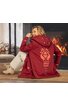 Rotes Damenjacke mit aufgesetzter Kapuze, großem orangefarbenem Muster auf dem Rücken, Reißverschluss, geschnittener Saum, getragen von sitzender Frau mit hellen Hosen und hellen Schuhen in Innenraum vor Kamin