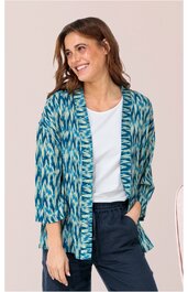 Offene Damenjacke mit blaubunten Ikat-Muster, 3/4-Ärmel, lockere Form, getragen von lächelnder Frau mit weißen T-Shirt und dunkler Hose