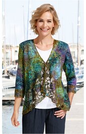 Multifarbige Damenjacke mit floralen Mustern, V-Ausschnitt, dreiviertellangen Ärmeln, gewelltem Saum, vorne offen mit Spitzenbesatz, getragen von stehender Frau vor Hafenkulisse