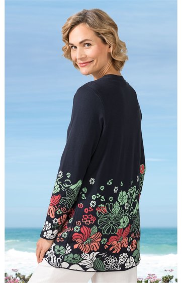 Langärmliges Oberteil in Dunkelblau mit floralem Muster in Rot, Grün und Weiß am unteren Ärmel- und Saumbereich, Rundhalsausschnitt, gerade geschnitten, getragen von stehender Frau, Rückenansicht, locker sitzend