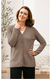 Braune Strickjacke mit V-Ausschnitt, durchgehenden Knöpfen, langärmelig, gerade geschnitten, getragen von lächelnder Frau mit schulterlangem Haar, stehend, eine Hand am Hals, andere in der Hüfte
