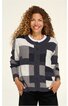 Damenstrickjacke mit Knöpfen, schwarz-weiß-grau kariert, Rundhalsausschnitt, lange Ärmel, gerade geschnitten, getragen von lächelnder stehender Frau mit lockigen Haaren, Hände in Taschen