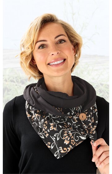 Schwarzes Dreieckstuch mit floralem Muster in Beige und Weiß, Holzknopf, getragen von lächelnder Frau, wird um den Hals getragen