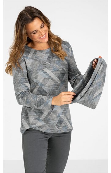 Langärmeliges Shirt in Grautönen mit geometrischem Muster, Rundhalsausschnitt, lockere Passform, getragen von stehender Frau, die eine Stoffbahn in der Hand hält