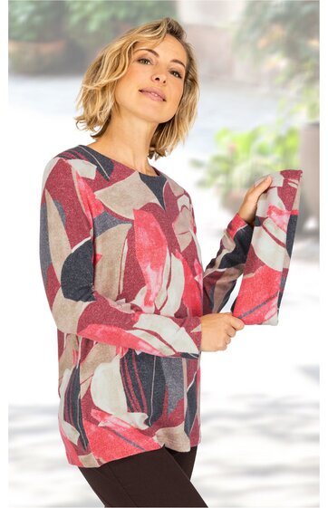 Langärmliges Damenshirt, mehrfarbig in Rot- und Beigetönen mit abstraktem Muster, rundhalsausschnitt, lockere Passform, getragen von stehender Frau, längere Saumline mit kleinen seitlichen Schlitzen