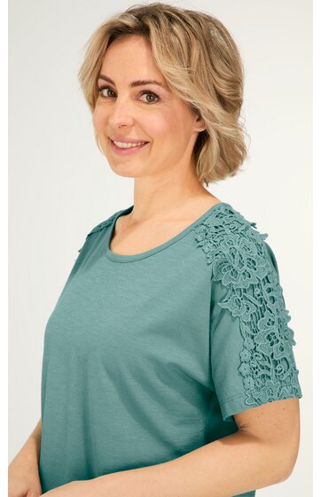 T-Shirt in graugrün, kurze Ärmel mit floraler Spitzenapplikation, Rundhalsausschnitt, gerade geschnitten, getragen von lächelnder stehender Frau, schlichtes Design
