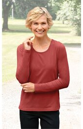 Rostrotes Langarmshirt ohne Muster, rundhals, gerade geschnitten, getragen von lächelnder stehender Frau im Grünen