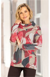 Langärmeliges Damenoberteil in Rot, Grau und Beige mit abstraktem Muster, hohem Kragen, gerade geschnitten, getragen von stehender Frau mit Hand am Kinn