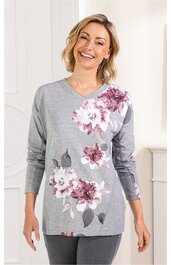 Graues Langarmshirt mit weißen und rosa Blumenmustern auf Vorderseite und Ärmeln, V-Ausschnitt, gerade geschnitten, getragen von lächelnder Frau in aufrechter Haltung