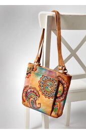 Umhängetasche mit Paisley-Muster in Beige, Orange und Grün, rechteckig, zwei lange Tragehenkel, auf weißem Stuhl hängend