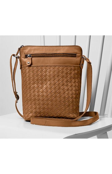 Braune Umhängetasche mit geflochtenem Muster, rechteckig, mit Reißverschlussfach vorne, verstellbarem Schulterriemen, auf weißem Holzstuhl sitzend