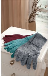 Drei Paar Handschuhe in bordeauxrot, türkis und graumeliert, gestrickt mit Fingerform, flach liegend auf weißer Kommode vor beiger Gardine und Vase mit Zweigen