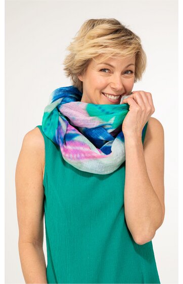 Grünes ärmelloses Oberteil, getragen von lächelnder Frau, bunter Schal in Blau, Grün, Pink und Weiß, locker um den Hals gelegt