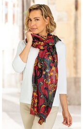 Roter Schal mit Paisley-Muster in Schwarz und Gelb, rechteckig, locker um den Hals einer stehenden Frau mit weißem Langarmshirt und beigen Hosen drapiert