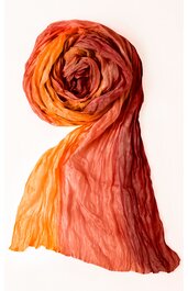 Schal in orange und rot mit Farbverlauf, leicht transparent, gekräuselt und locker zusammengerollt, rechteckig, weiche Struktur sichtbar